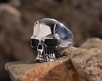 Puede incluir: Un anillo de calavera de plata con un diseño detallado. El anillo está hecho de metal y tiene un acabado pulido.