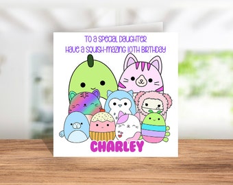 May include: A birthday card featuring a colourful cartoon design with a variety of squishmallows. The card reads "To a special daughter Have a squish-mazing 10th birthday CHARLEY".