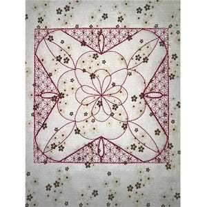 Puede incluir: Un cuadrado de tela blanca con un diseño bordado en rojo. El diseño presenta un patrón geométrico con una flor en el centro.