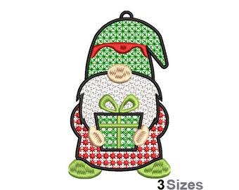 May include: A green and red Christmas gnome holding a green gift box with a green bow. The gnome has a white beard and a red hat.