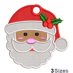 Puede incluir: Adorno de Navidad bordado con un Papá Noel de dibujos animados con barba blanca, piel morena y un gorro rojo con acebo verde.