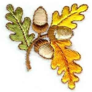 May include: Embroidered autumn-themed design featuring acorns and oak leaves. The leaves are rendered in shades of green and yellow, with detailed stitching and gold accents. The acorns have a beige cap and brown base.
