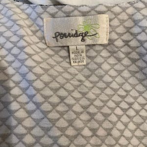 Puede incluir: Primer plano de una tela estampada en blanco y gris. La tela tiene un dise&ntilde;o de diamantes repetidos. Una etiqueta dice "Porridge" con el texto "Made in India Fabriqu&eacute; en Inde".
