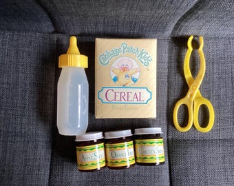 Vintage 1980s Xavier Robert’s Cabbage Patch Kids CPK Feeding Set, Yellow Baby Bottle, Food Jars, Cereal Box