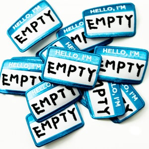 Könnte beinhalten: Ein Stapel blauer und weißer Namensschilder mit dem Text "HELLO, I'M EMPTY" auf jedem Schild.