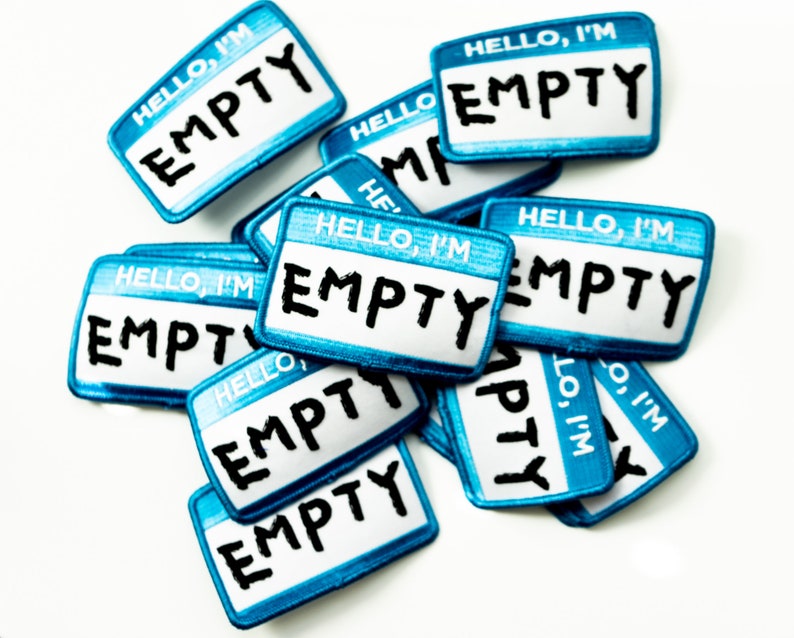 May include: A pile of blue and white name tags with the text "HELLO, I'M EMPTY" on each tag.