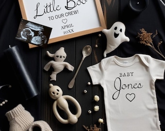May include: A Halloween-themed baby announcement featuring a framed sign with the text "We are adding a Little Boo to our crew!" and "April 20XX." Includes a baby onesie, ultrasound image, and ghost-shaped decorations.