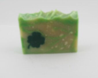 May include: A green and white bar of soap with a four-leaf clover design.