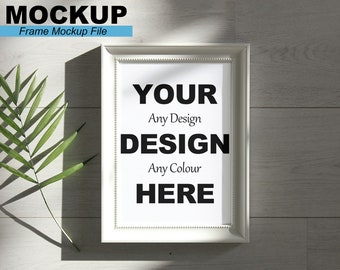 Op de afbeelding: Witte fotolijst mockup met een witte passe-partout en een witte achtergrond. De tekst "YOUR DESIGN" staat in het zwart op de witte achtergrond. De tekst "Any Design" staat onder "YOUR" en de tekst "Any Colour" staat onder "DESIGN". De tekst "HERE" staat onder "Any Colour".