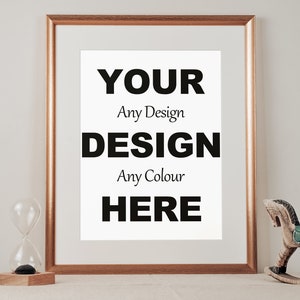 Puede incluir: Un marco de color dorado con un paspartú blanco y un texto superpuesto en blanco y negro que dice "YOUR Any Design DESIGN Any Colour HERE". El marco está sobre una superficie beige claro con un reloj de arena de vidrio y un caballo de balancín de madera.