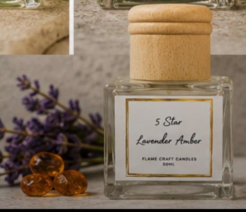 May include: A square glass bottle with a light wood cap, featuring a white label with a gold border. The label reads 5 Star Lavender Amber, Flame Craft Candles, 50ml. The bottle is accompanied by purple lavender sprigs and three amber-colored stones.