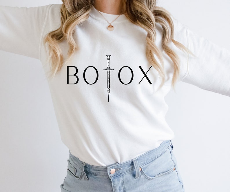 May include: White sweatshirt with the word "BOTOX" printed in black with a black and white illustration of a syringe in between the "O" and the "X".