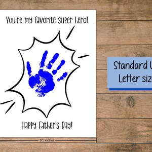 Peut inclure: Une carte blanche avec du texte noir qui dit "You're my favorite super hero!" et "Happy Father's Day!" avec une empreinte de main bleue &agrave; l'int&eacute;rieur d'une bulle de dialogue de style bande dessin&eacute;e noire et blanche. La carte mesure 8,5 pouces par 11 pouces.