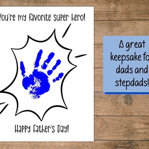 Peut inclure: Une carte blanche avec une empreinte de main bleue dans une bulle de dialogue de style bande dessin&eacute;e noir et blanc. La carte dit "You're my favorite super hero!" et "Happy Father's Day!" Une note bleue sur le c&ocirc;t&eacute; droit de la carte dit "A great keepsake for dads and stepdads!"