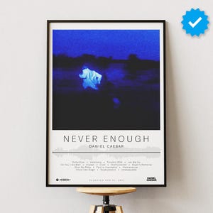 Puede incluir: Un póster enmarcado con borde negro presenta el texto "NEVER ENOUGH" y "DANIEL CAESAR" en blanco. La obra de arte tiene un fondo azul oscuro y negro con una imagen borrosa. Los títulos de las canciones están listados debajo.