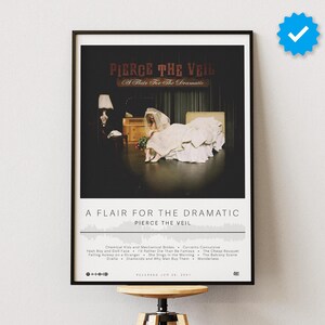 May include: A framed poster featuring the album art for "A Flair for the Dramatic" by Pierce the Veil. The artwork depicts a stage scene with a bride in a wedding dress. The poster includes the album title, band name, and tracklist.