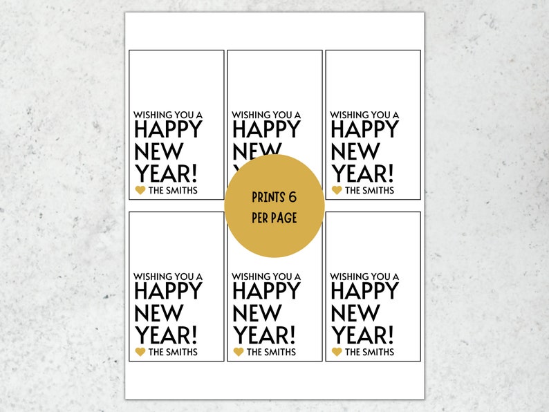 Op de afbeelding: Zes printbare cadeaulabels met een gouden hart en de tekst "Wishing you a Happy New Year!" gevolgd door "The Smiths". De tekst "Prints 6 per page" staat in een gouden cirkel.