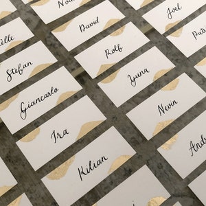 Handgeschriebene Tischkarten mit Goldelementen für Hochzeiten