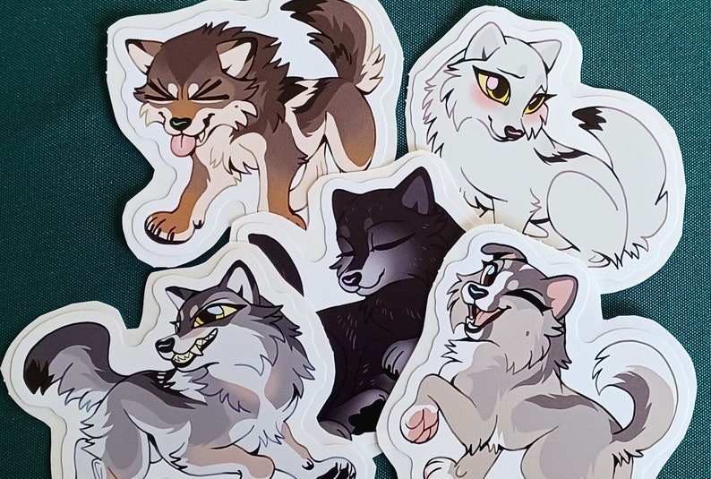 May include: Five cartoon wolf stickers with different expressions. The stickers are white with black outlines and feature different colored fur. The wolves are all in different poses.
