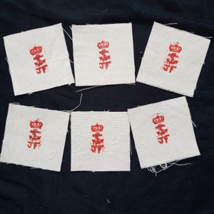 Pode incluir: Seis quadrados de tecido branco com caracteres chineses vermelhos impressos neles. Os caracteres são de estilo tradicional e estão dispostos verticalmente. Os quadrados são todos do mesmo tamanho e estão dispostos em uma grade.