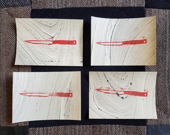 Könnte beinhalten: Vier weiße rechteckige Karten mit einem roten Messerbild und dem Wort "Whiskey" in rot auf jeder Karte.