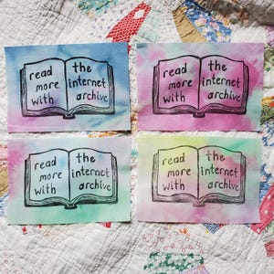 May include: Four colorful art prints with the text "read more with the internet archive" printed on an open book illustration. Each print has a different watercolor background in shades of blue, pink, green, and yellow.