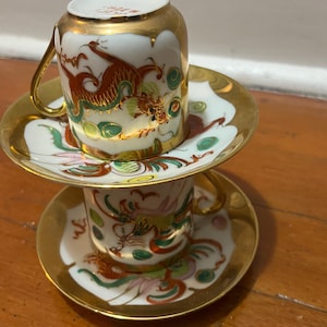 Chinese teacup and saucer set of two ; Chinese demitasse teacups and saucers in red and gold porcelain-ceramic.
