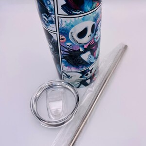 May include: A white stainless steel tumbler with a colorful graphic print of Jack Skellington and Sally from the Nightmare Before Christmas. The tumbler comes with a clear lid and a stainless steel straw.
