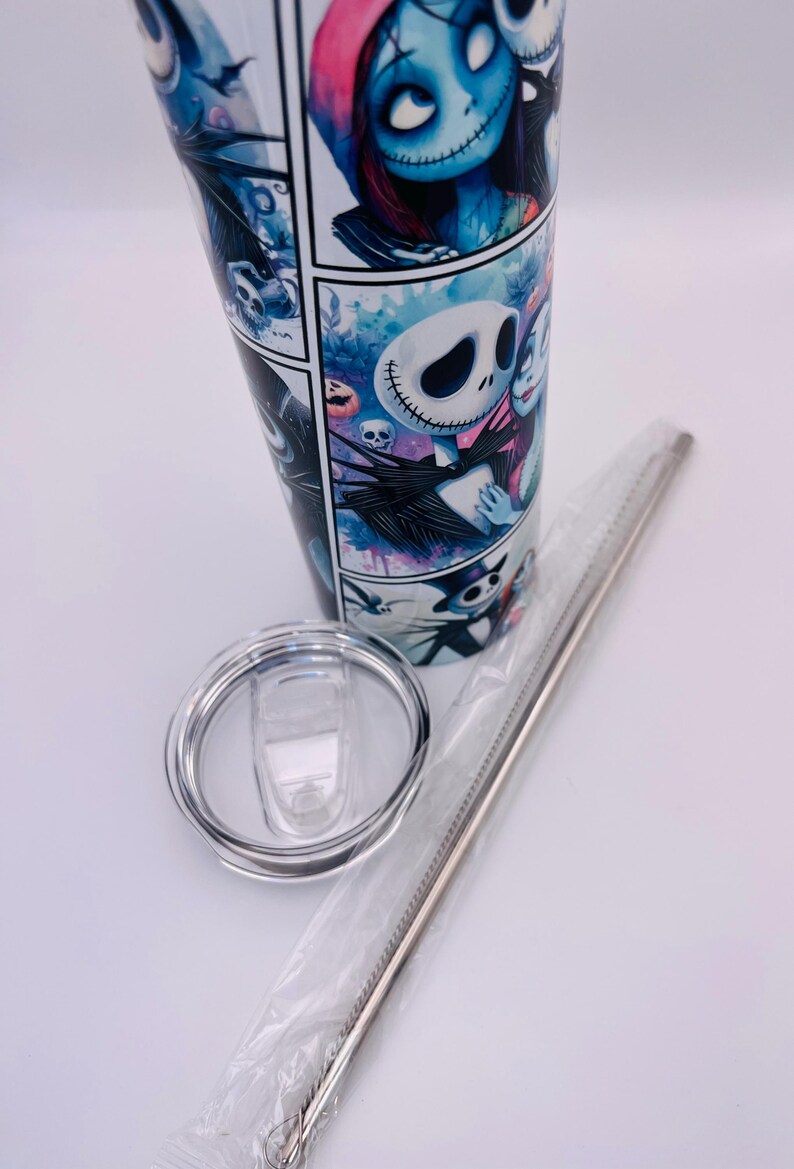 May include: A white stainless steel tumbler with a colorful graphic print of Jack Skellington and Sally from the Nightmare Before Christmas. The tumbler comes with a clear lid and a stainless steel straw.