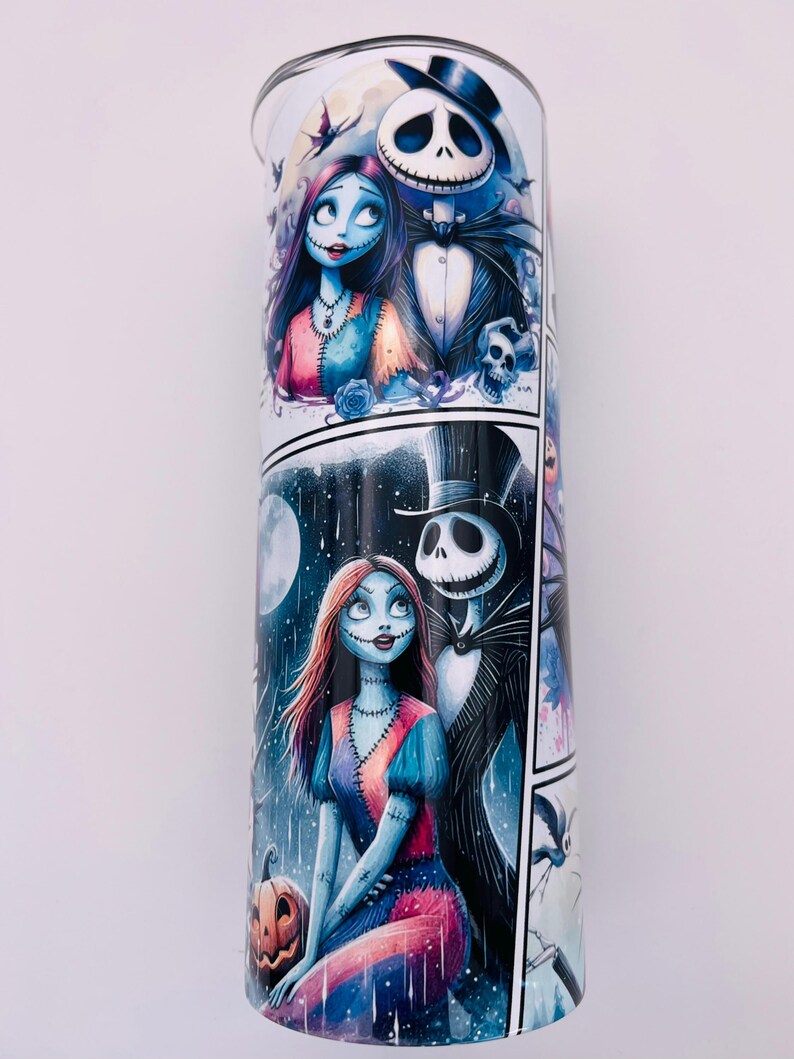 May include: A white tumbler with a colorful cartoon image of Jack Skellington and Sally from the Nightmare Before Christmas. The image is in a comic book style with multiple panels.