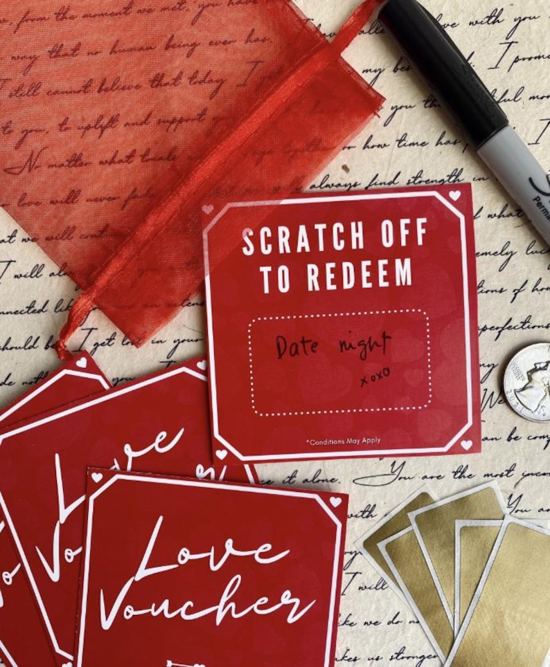 May include: A collection of red love vouchers and scratch-off cards with white text and borders. One card reads "Scratch Off To Redeem" with "Date night" written below. A red mesh gift bag and a black marker are also visible.