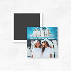 May include: A white framed magnet with a black interior. Below it, a rectangular magnet features a concert image with the text "August 16, 2025 | Sphere Las Vegas". The bottom half shows two people in white shirts and sunglasses.