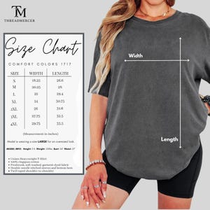 May include: Dark grey unisex heavyweight t-shirt with a size chart. The size chart shows measurements in inches for sizes S to 4XL. The shirt is made of 100% ringspun cotton and has double-needle stitched sleeves.