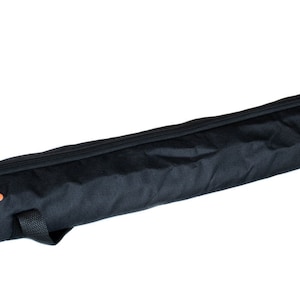 May include: Black, long, cylindrical carrying case with the word "PLAYMATS" in orange lettering. The case has a zipper closure and a handle on the side. The case is designed to carry a long, rolled item.