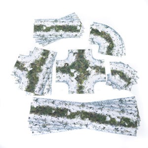 Könnte beinhalten: Eine Sammlung von Modelleisenbahn-Gleisbauteilen, darunter gerade Abschnitte, Kurven und eine Kreuzung, alle mit einem schneebedeckten Gelände-Design mit grüner Vegetation. Die Teile sind auf weißem Hintergrund angeordnet.