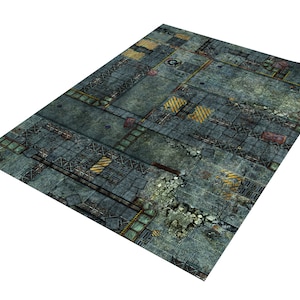 Puede incluir: Una alfombra de juego rectangular con un diseño industrial detallado. La alfombra presenta una apariencia de hormigón gris desgastado con rayas amarillas de peligro, rejillas metálicas y daños simulados, creando un entorno post-apocalíptico o urbano.