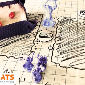Puede incluir: Una configuraci&oacute;n de juego de rol de mesa con una bandeja de dados, dados, figuras en miniatura y un mapa de juego. La bandeja de dados es de color p&uacute;rpura oscuro y los dados son rojos y negros. El mapa del juego es blanco con l&iacute;neas y garabatos negros.