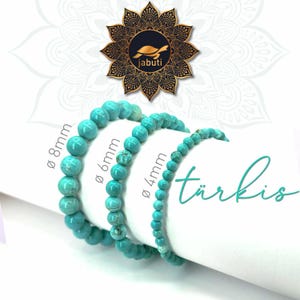 Könnte beinhalten: Drei türkisfarbene Perlenarmbänder mit unterschiedlichen Perlendurchmessern von 8mm, 6mm und 4mm. Die Armbänder werden mit dem Text "türkis" und einem Logo mit einer Schildkröte und dem Wort "jabuti" in einem kreisförmigen Mandala-Design gezeigt.