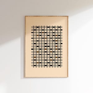 May include: Framed artwork featuring a grid pattern. The design consists of black vertical and horizontal lines, with alternating brown and black squares. The artwork is set against a beige background and framed in a light wood.
