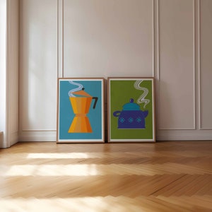 May include: Two framed prints of kitchenware. The print on the left shows a gold-colored coffee pot with steam rising from the spout. The print on the right shows a blue teapot with steam rising from the spout. Both prints have a green background.