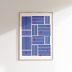 May include: Abstract art print featuring a geometric design of blue vertical and horizontal lines, with red dots at the intersections. The artwork is framed in a light wood frame, creating a modern aesthetic. The print is displayed against a white wall.