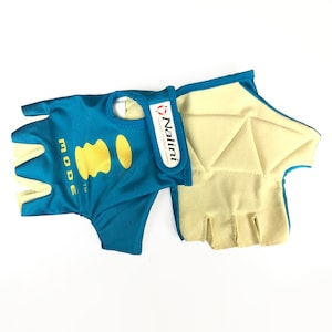 Può includere: Un paio di guanti da ciclismo senza dita blu e gialli con un logo Nalini bianco e rosso. I guanti hanno un palmo imbottito.