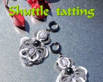 Può includere: Un paio di orecchini in tatting a navetta bianchi e argentati con perline nere. Gli orecchini sono appesi ad anelli argentati. L'immagine include il testo "Shuttle tatting" e "Tatting Tutorial PDF".