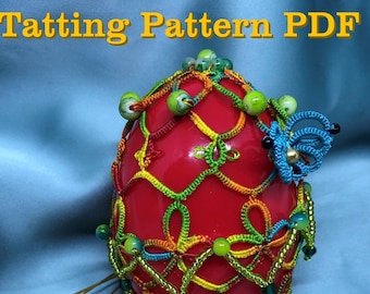 May include: A red egg covered in a colorful crocheted pattern with green, yellow, and blue thread. The egg is decorated with small beads and a blue butterfly. The text "Tatting Pattern PDF" and "Shuttle tatting" is visible in the image.