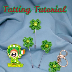 Pode incluir: Três pingentes de renda tatting em forma de trevo verde com contas verdes e um chaveiro dourado. Os pingentes são presos a alfinetes prateados e o chaveiro é preso a um anel dourado. Os pingentes estão sobre um fundo de tecido azul claro com o texto "Tatting Tutorial Shuttle" em verde.