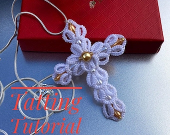Può includere: Ciondolo a croce bianco lavorato a uncinetto con perline dorate, appeso a una catena d'argento. La croce è su una superficie grigia con il testo "Tatting Tutorial ENGLISH" in rosso.