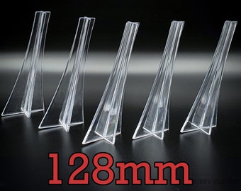 May include: Five clear plastic display stands, each measuring 128 mm in height. The stands are designed to elevate and showcase small items.