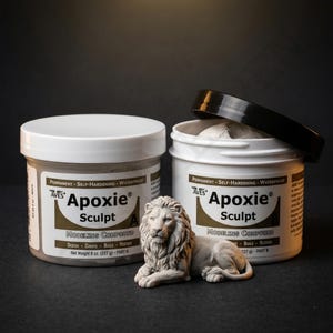 May include: Two white containers of Aves Apoxie Sculpt modeling compound, with a lion sculpture in front. The containers have black lids and labels with text. The lion is a light gray color.