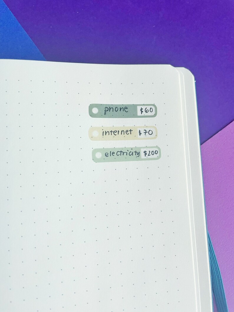 May include: A white page with three green and beige rectangular stickers with handwritten text. The stickers list phone, internet, and electricity with their corresponding prices. The prices are $60, $70, and $200.