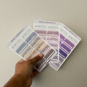 May include: Three sheets of weekly tracker stickers with different color schemes. The stickers are labeled "Weekly Tracker Set 1", "Weekly Tracker Set 3", and "Weekly Tracker Set 4". Each sheet has a grid of circles with the days of the week labeled across the top.